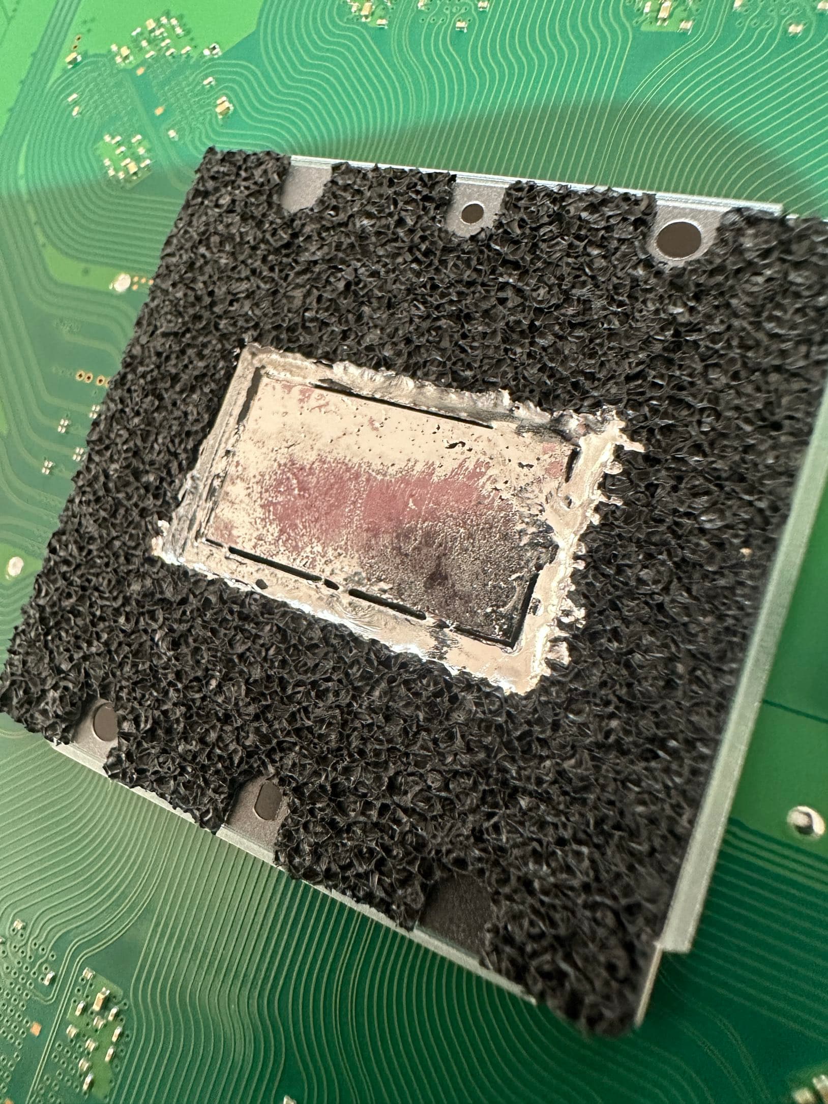 Ausgetrocknetes und verlaufenes Flüssigmetall auf dem APU-Chip der PlayStation 5