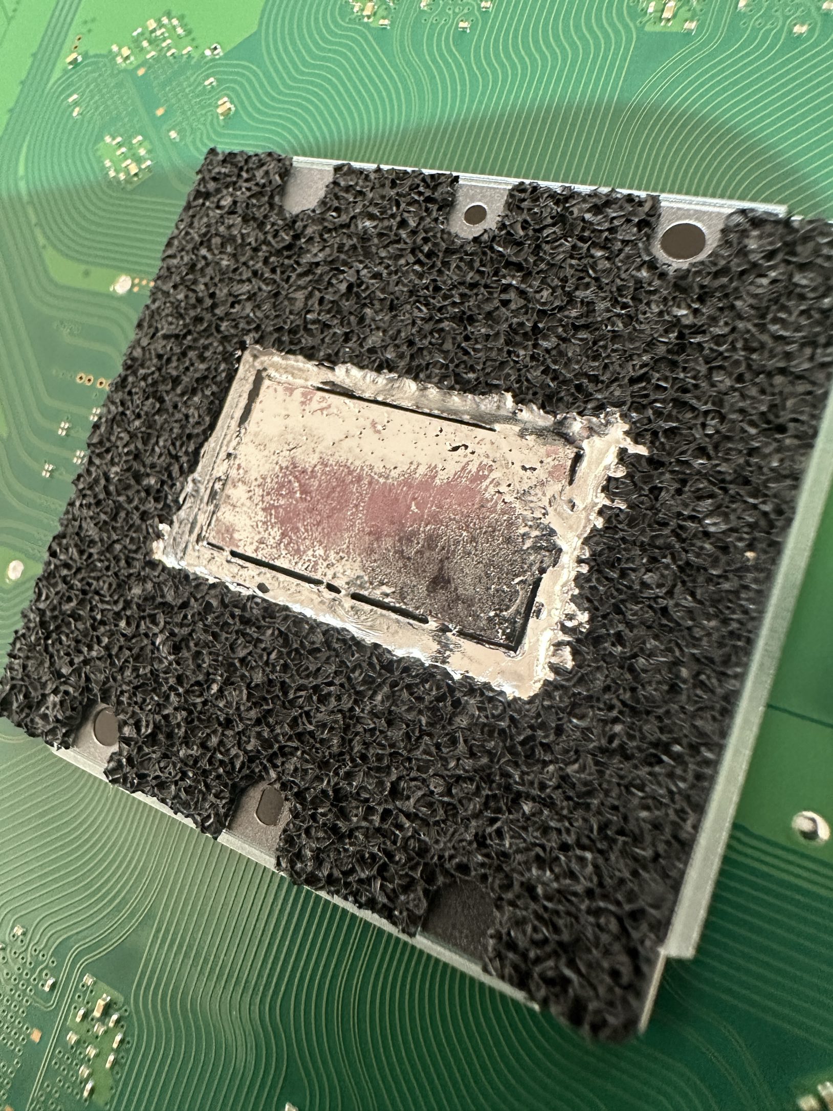 Ausgetrocknetes und verlaufenes Flüssigmetall auf dem APU-Chip der PlayStation 5